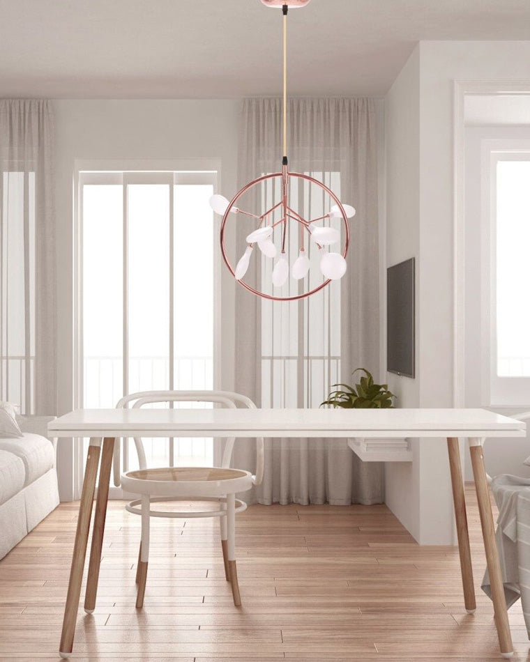Rose-gold Firefly small chandelier above a bright table, providing elegant kitchen island lighting without making the open interior feel crowded.