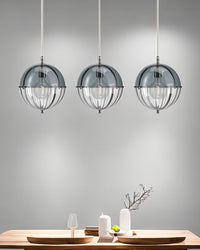 Three blue glass pendant lights suspended in a row above a dining table.