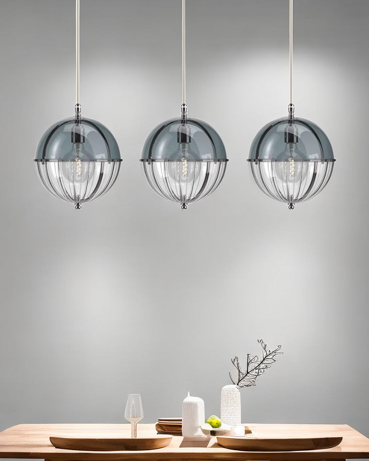 Three blue glass pendant lights suspended in a row above a dining table.