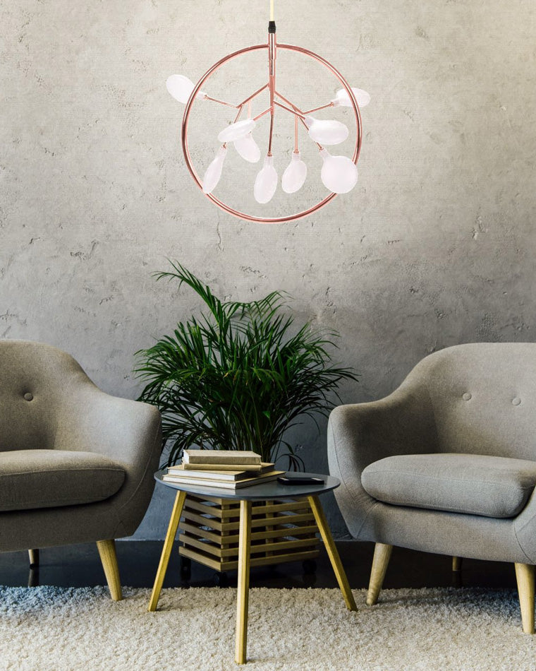 Circular Heracleum chandelier glowing between two lounge chairs, creating restful ambient lighting for reading, conversation, and quiet evenings.