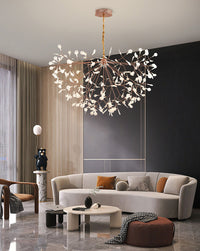 Wide rose-gold sculptural chandelier anchoring a neutral contemporary living room with graceful scale, movement, and warm illumination.