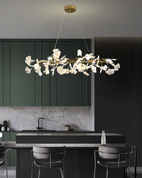 Black ceramic leaf chandelier over a dark green kitchen island and dining counter.