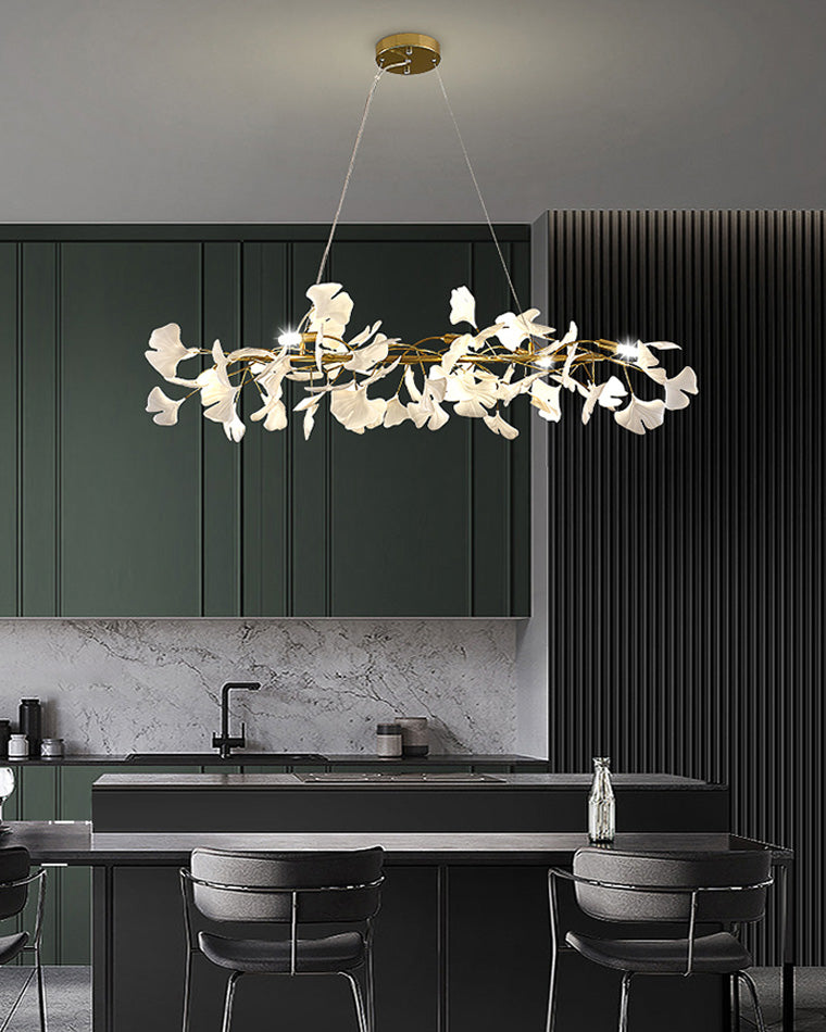 Black ceramic leaf chandelier over a dark green kitchen island and dining counter.