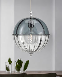 Blue glass globe hanging light styled above a console with green tulips.