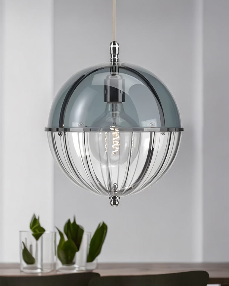 Blue glass globe hanging light styled above a console with green tulips.