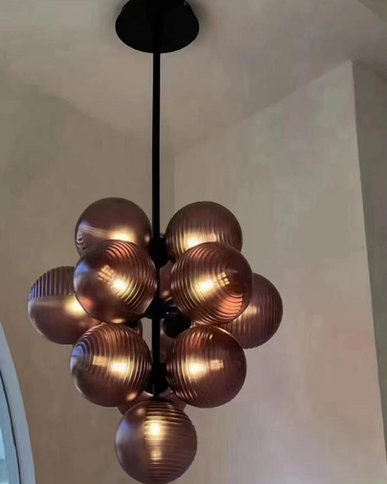 Close-up underside view of glowing purple glass bubbles clustered around the chandelier frame.