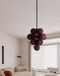 Deep purple glass chandelier suspended in a softly lit modern living space.