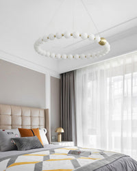 Airy bedroom chandelier brings diffused light and a calm pearl-ring silhouette above the bed without making the serene room feel visually heavy.