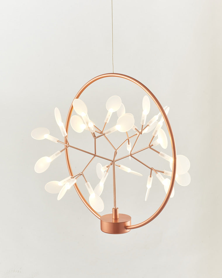 Illuminated Firefly small chandelier with delicate branches crossing its rose-gold ring, bringing the crafted character of designer chandeliers to compact rooms.