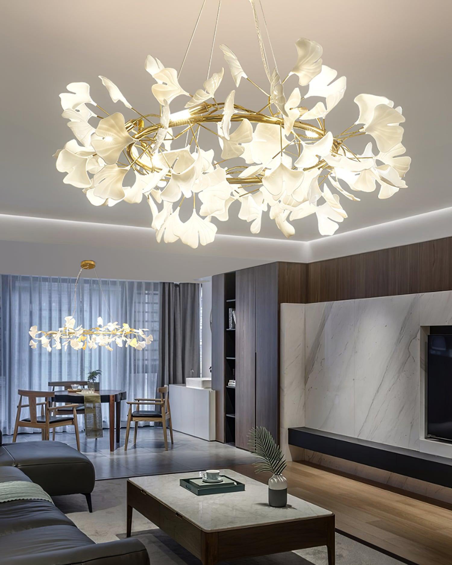 Gold-framed round leaf chandelier over a dining area in an open-plan living room.