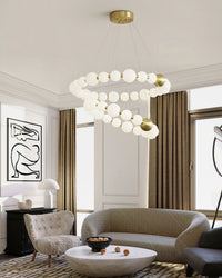 Two glowing pearl rings sweep through the living room ceiling, creating sculptural movement and a layered focal point above the curved seating area.