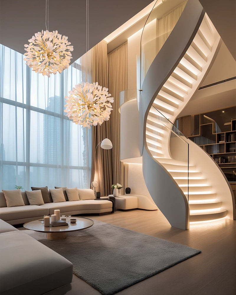 A double-height modern living room with a spiral staircase and floor-to-ceiling windows; two white ginkgo leaf chandeliers hang from above, adding warm ambient lighting.
