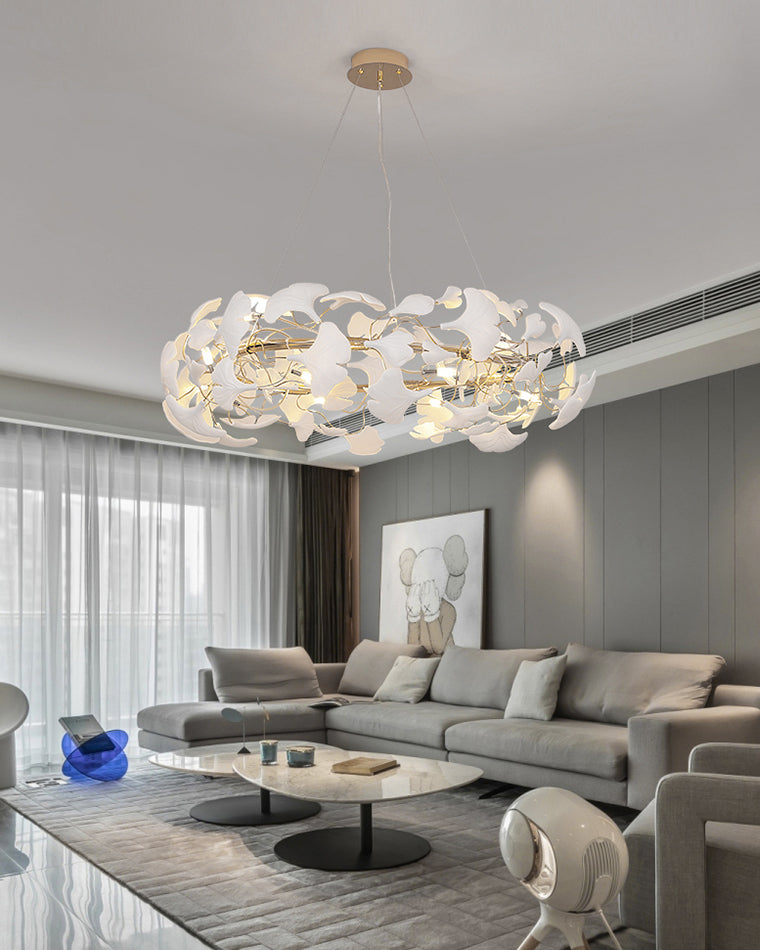 WM2419 round chandelier above a gray sectional, balancing warm light and white ceramic leaves in a contemporary living room.