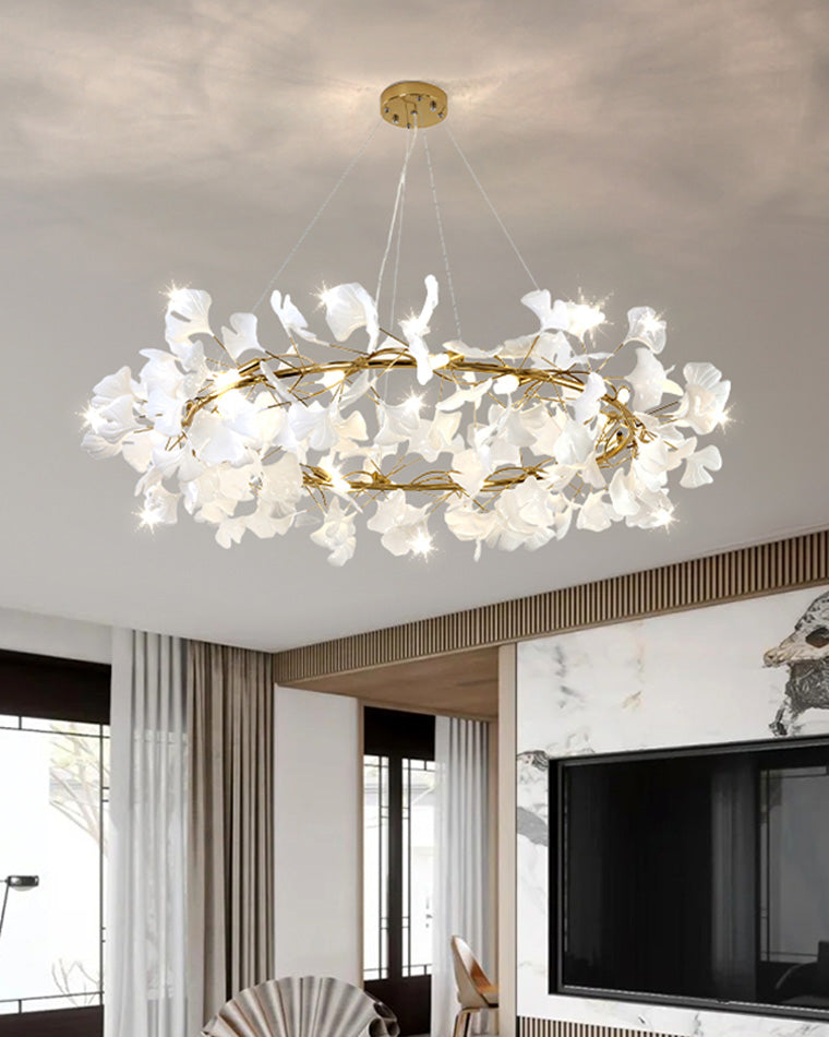 Round white ceramic leaf chandelier lighting a contemporary living room with a marble TV wall.