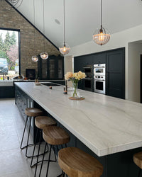 Clear-and-white glass globe pendants creating a warm focal point above a large kitchen island.