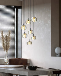 Modern glass chandelier styled beside a neutral living area, using a soft cascading silhouette to create sculptural ambient light.