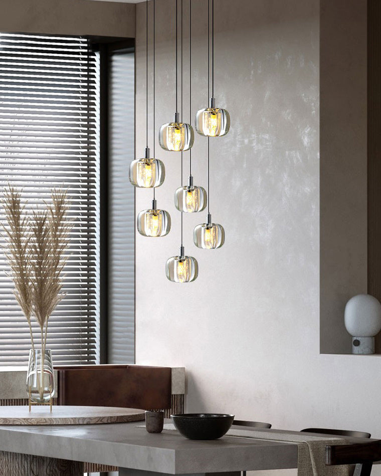 Modern glass chandelier styled beside a neutral living area, using a soft cascading silhouette to create sculptural ambient light.