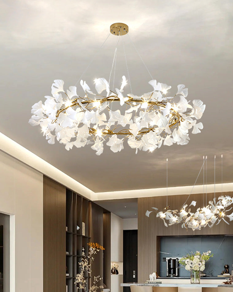 Gold-framed ceramic leaf chandelier in an open kitchen, paired with a matching linear fixture.
