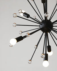 Close-up from below of the black Sputnik chandelier, showing the central metal hub, slim radial arms, clear glass spheres, and replaceable bulbs.