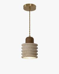 A ribbed pendant light in pale travertine with a walnut wood top, twisted cord and brass-tone ceiling plate, shown lit against white.