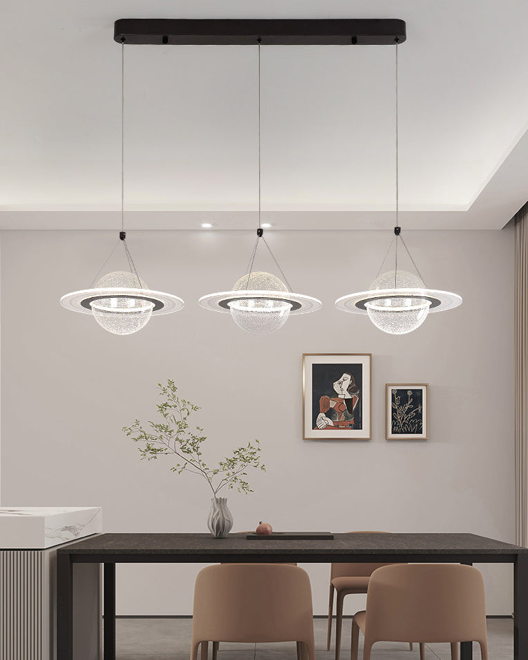 Three evenly spaced planet pendants form a linear chandelier dining room arrangement above a long black table in a neutral minimalist interior.