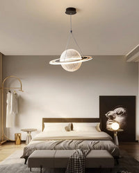 Large globe pendant light with a luminous LED orbit ring centered above a modern neutral bed as a sculptural bedroom focal point.