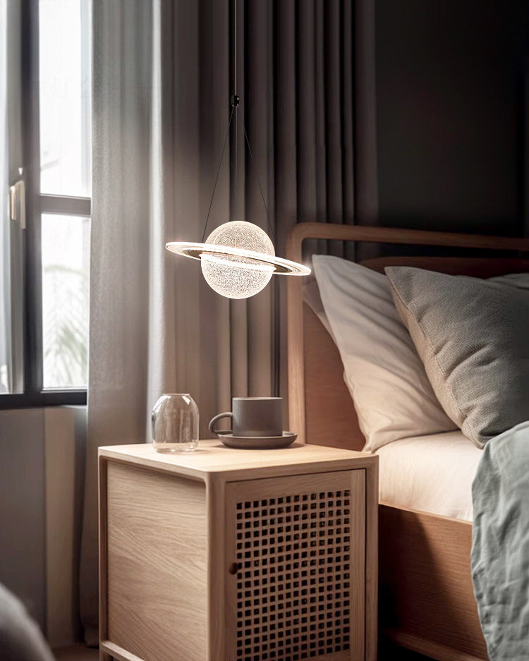 Warm bedroom lighting from a hanging globe light fixture above a cane-front nightstand beside a natural wood bed.