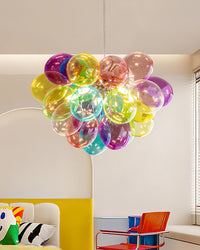 Illuminated globe chandelier with layered multicolor glass bubbles above colorful seating in a bright modern living space.
