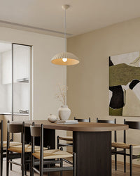 White plaster dome pendant centered above a dark kitchen island with bar stools, creating understated kitchen island lighting in an open-plan space.