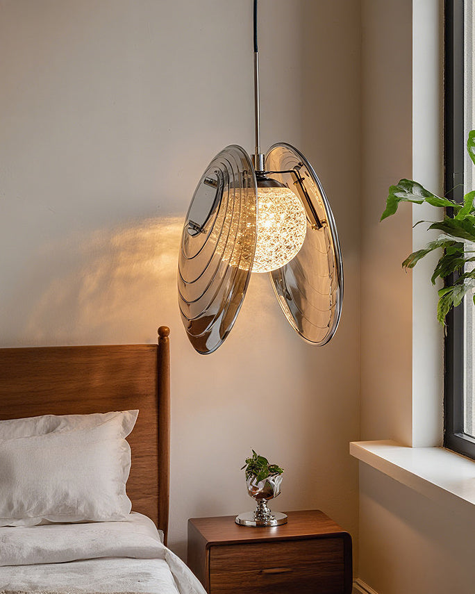 Smoke grey glass disc pendant light with layered tinted glass discs and a glowing center, shown as a clean studio product image.