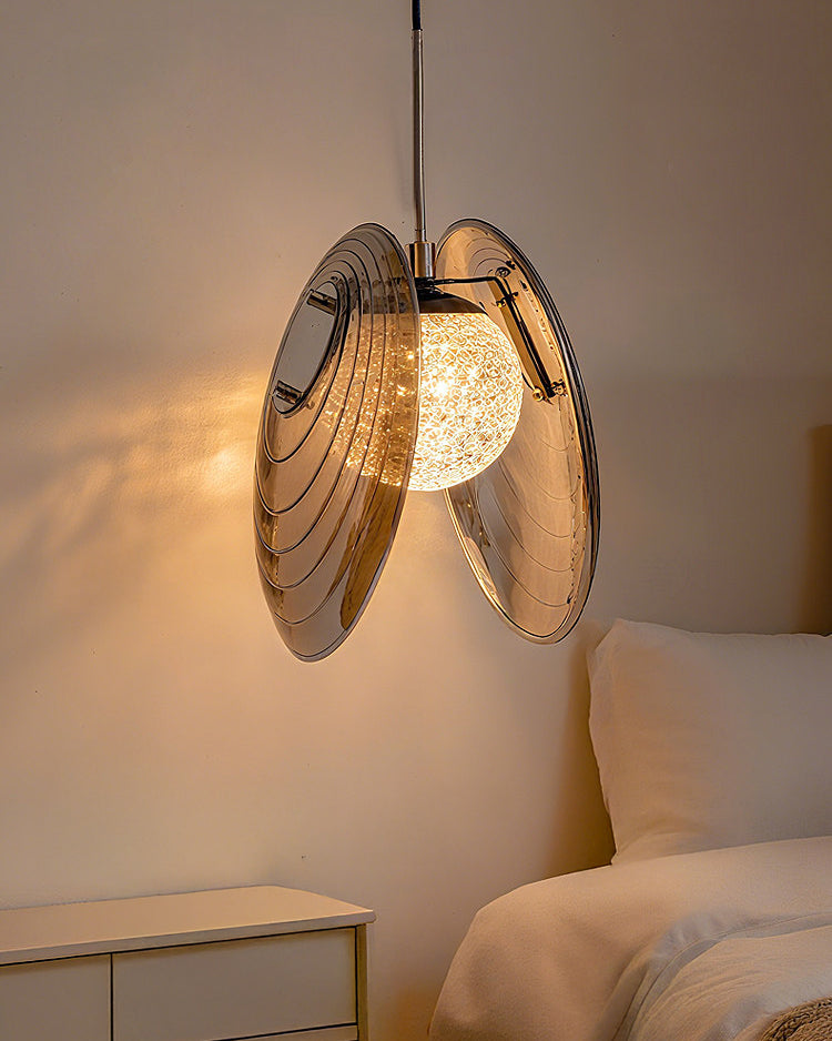 Compact smoke grey bedside pendant light suspended beside a bed and curtain for a warm, space-saving glow.