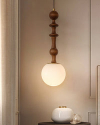 Wooden pendant light with a white glass shade on a neutral wall.