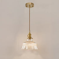 Narrow flower pendant lamp with a clear ribbed glass shade, warm light, twisted cord, brass hardware, and round canopy.