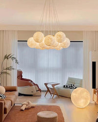 Thirteen-light multiple bubble chandelier above a neutral living room, creating a wide cloud-like cluster of warm glowing textured PLA globes.