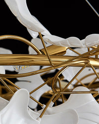 Close-up of the gold branching frame and layered white ceramic ginkgo leaves.