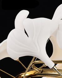 Close view of softly lit white ginkgo leaf shades branching from the gold-toned copper frame.