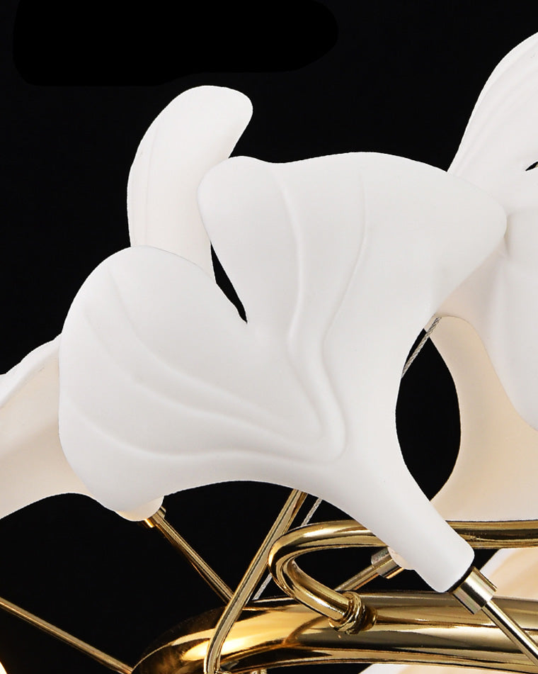 Close view of softly lit white ginkgo leaf shades branching from the gold-toned copper frame.