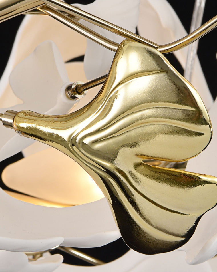 Reflective gold ginkgo leaf detail catching light beside illuminated white leaf shades.