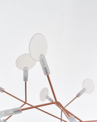 Close-up of translucent leaf-shaped lights, showing how the firefly chandelier diffuses a soft glow instead of harsh, exposed brightness.