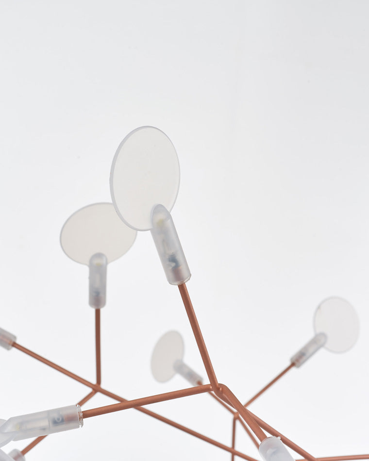 Close-up of translucent leaf-shaped lights, showing how the firefly chandelier diffuses a soft glow instead of harsh, exposed brightness.
