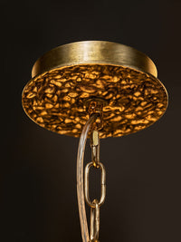 Ceiling-mount detail for the WOMO WM3353 branch chandelier, showing its round golden canopy, textured underside, chain links and clear cord.