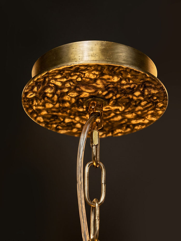 Ceiling-mount detail for the WOMO WM3353 branch chandelier, showing its round golden canopy, textured underside, chain links and clear cord.