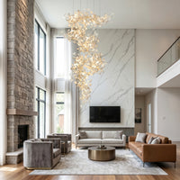 Ceramic chandelier for high ceiling living room, cascading beside a marble feature wall in a bright two-story interior.