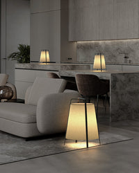 Three paper lantern floor lamps creating soft ambient light across an open-plan living and dining space.