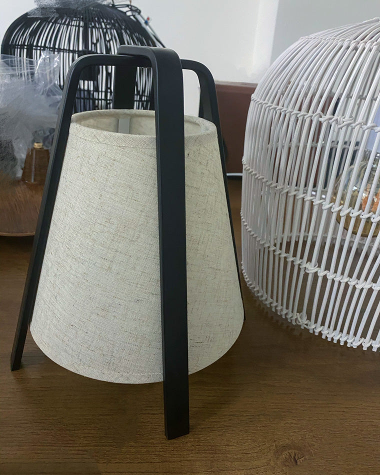Close-up of the beige paper shade and black metal frame showing the lantern-inspired silhouette.