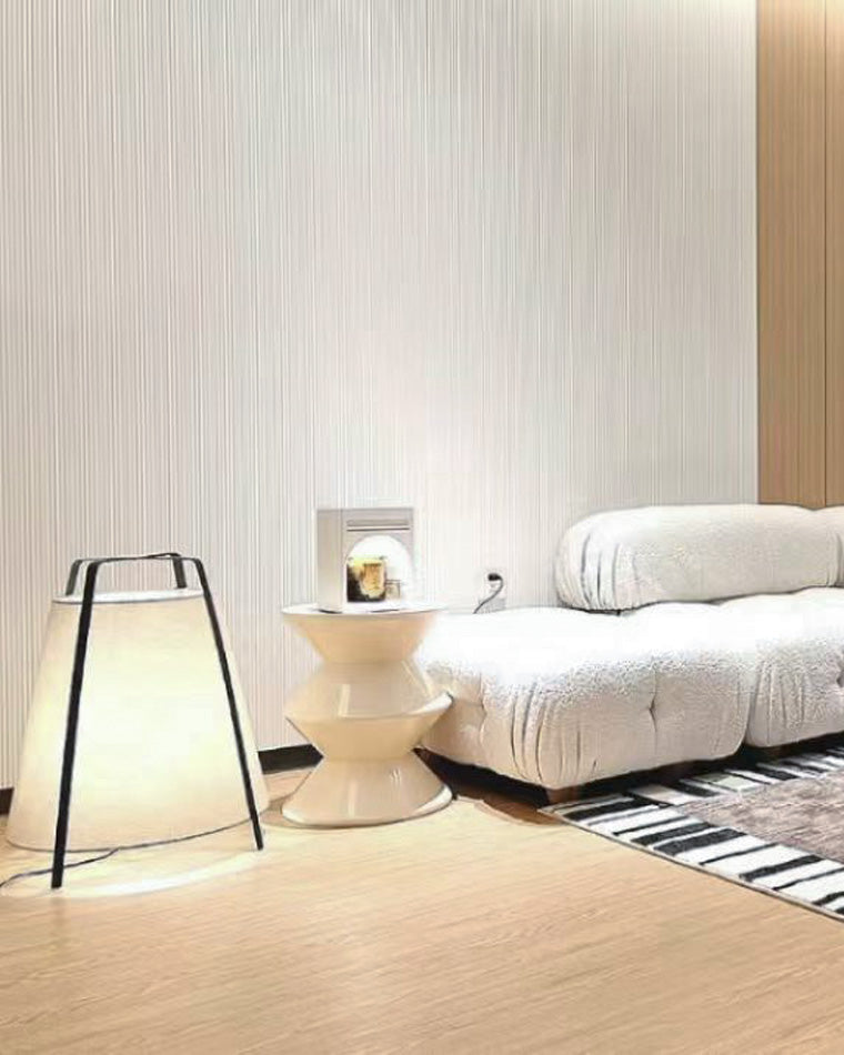 Beige paper lantern lamp placed beside a bed and sculptural side table, showing low-profile accent placement.
