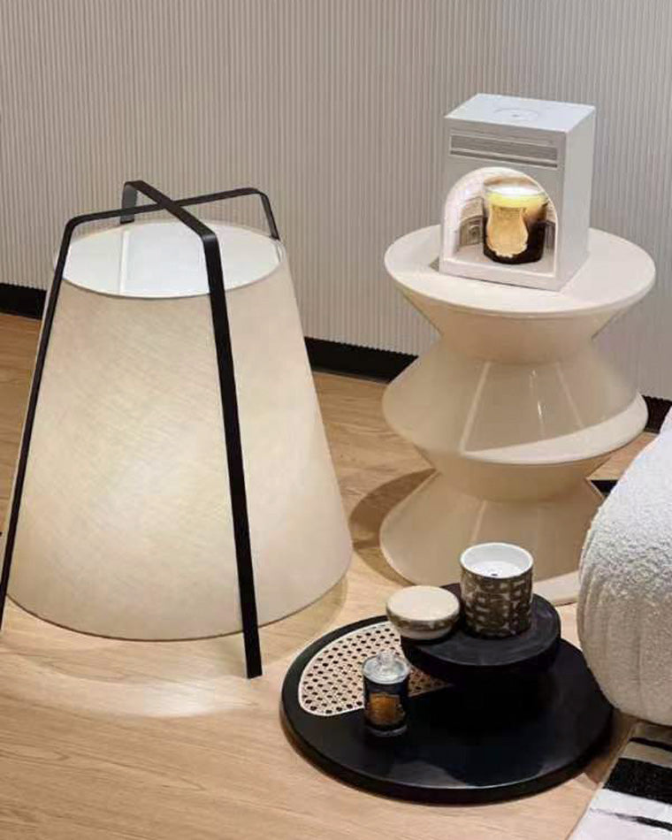 Close view of the lantern lamp beside the bed, highlighting the soft glow and tapered shade shape.
