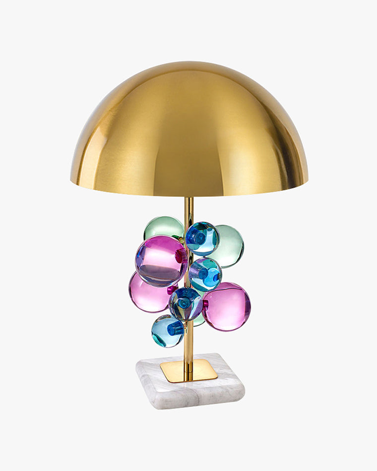 WOMO WM8008 mushroom table lamp with a brass dome, pink, blue and green acrylic orbs, and a square white marble base on a white background.