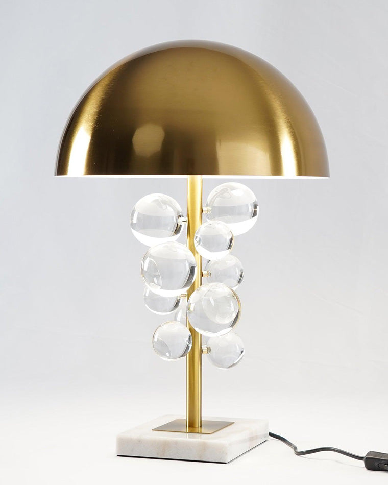 Clear marble base table lamp with transparent acrylic spheres, brass stem and dome, photographed on a white background with its power cord.