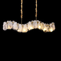 Illuminated 39-inch modern linear chandelier with layered white-swirled glass forms and visible lights along a curved gold frame against a black background.